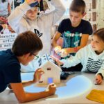Kinder leuchten mit einer Taschenlampe auf Solarzellen